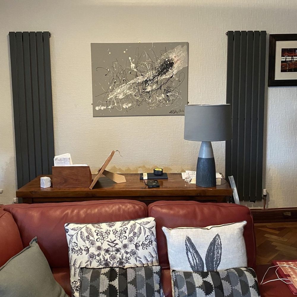 Two anthracite vertical radiators installed in a living room